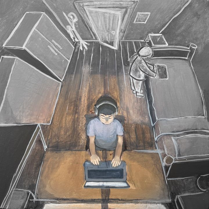 A boy at a laptop seen from above in a grey room