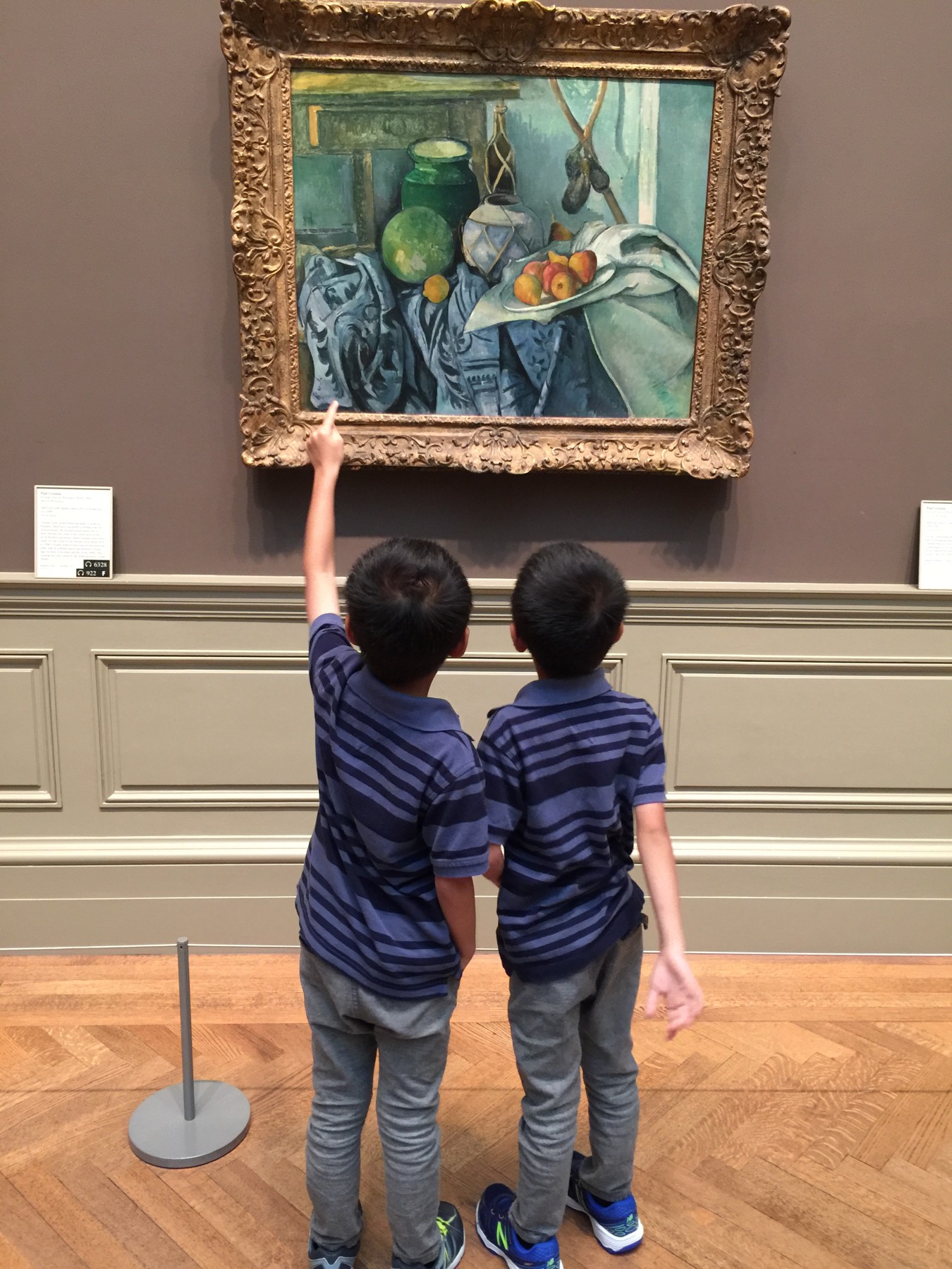 My brother and me studying a framed still-life painting in a museum